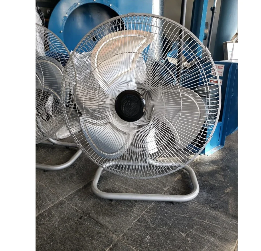 Ventilador circulador industrial de piso. Estructura metálica baja, hélice plástica y rejilla protectora.
